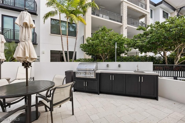 view of patio / terrace with area for grilling, a grill, outdoor dining area, and a sink