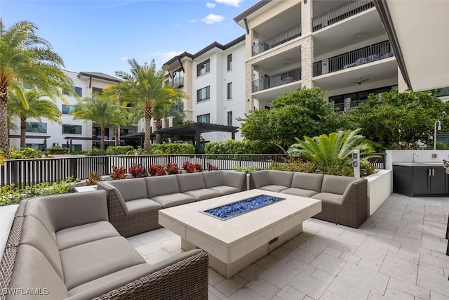 view of patio / terrace featuring an outdoor living space with a fire pit and fence