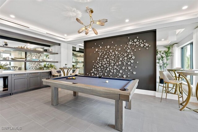 recreation room with a raised ceiling and billiards