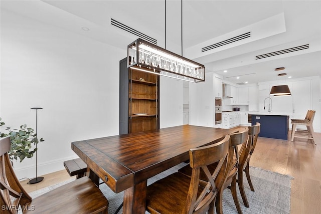 dining area featuring visible vents, baseboards, and light wood-style flooring