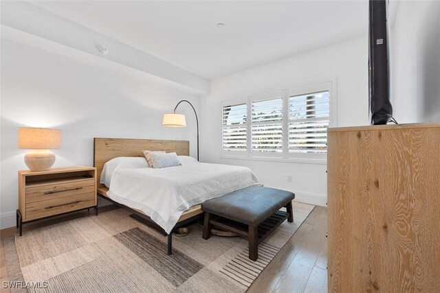 bedroom featuring baseboards and wood-type flooring