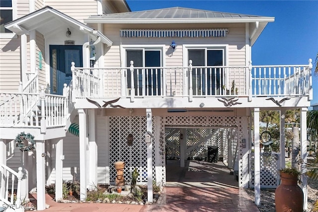 rear view of property with a balcony and a carport