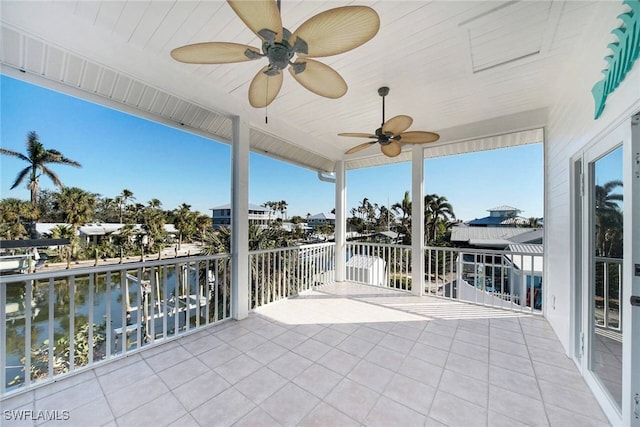 view of patio featuring a balcony, ceiling fan, and a water view