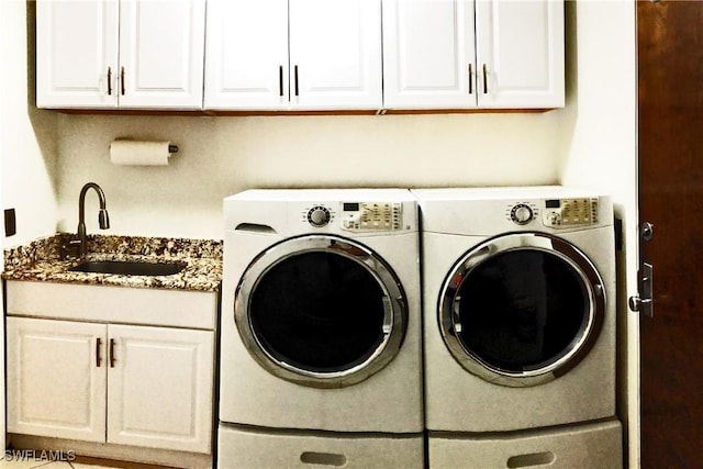 laundry area featuring sink, washer and clothes dryer, and cabinets