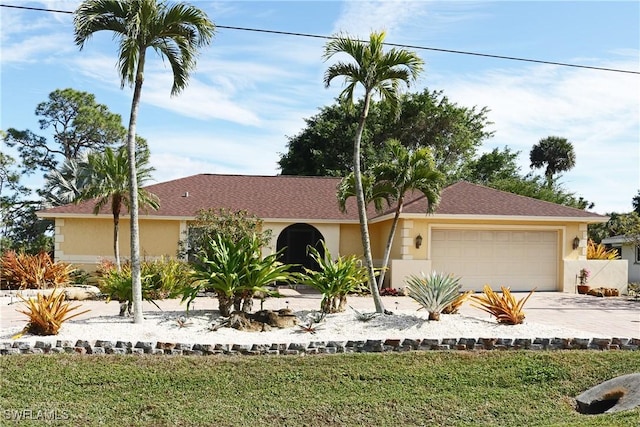 ranch-style house featuring a garage and a front lawn