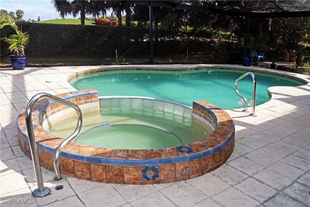 view of pool with an in ground hot tub and a patio