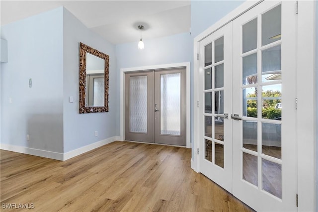 entryway with french doors and light hardwood / wood-style flooring