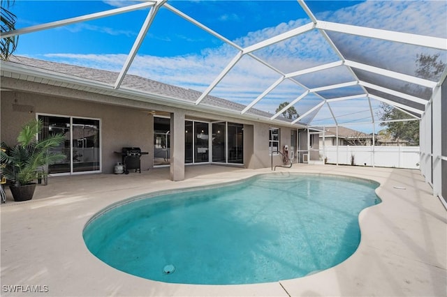 view of pool featuring area for grilling, a patio area, and glass enclosure