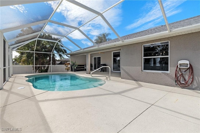 view of pool with ceiling fan, a lanai, and a patio