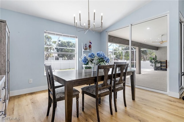 dining room with vaulted ceiling, a notable chandelier, and light hardwood / wood-style flooring