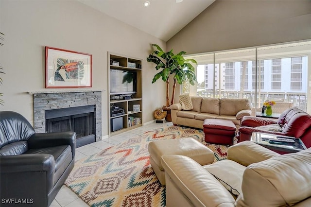 living room with vaulted ceiling, light tile patterned floors, and a stone fireplace