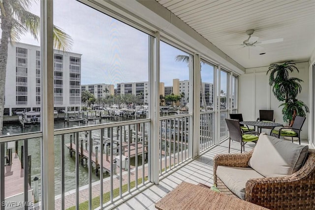 sunroom featuring a water view and ceiling fan