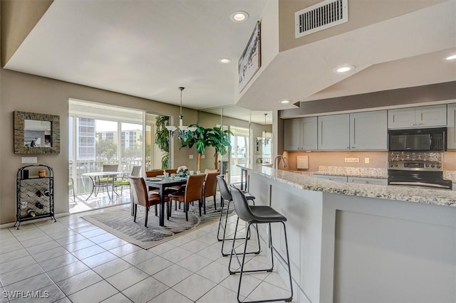 kitchen with gray cabinets, stainless steel electric stove, plenty of natural light, and pendant lighting