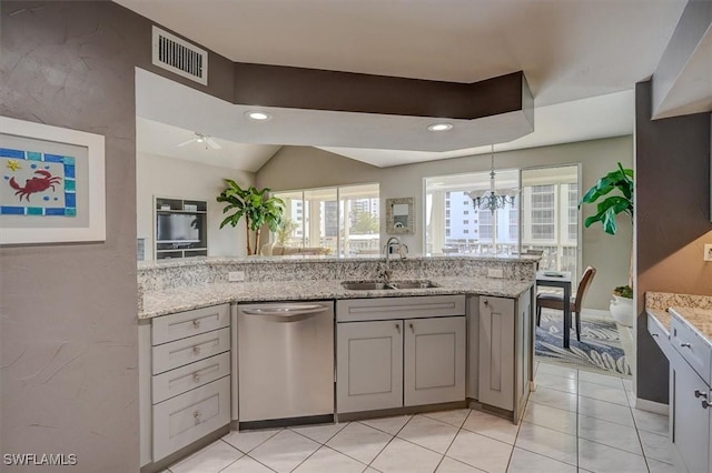 kitchen featuring light stone countertops, sink, stainless steel dishwasher, and gray cabinetry