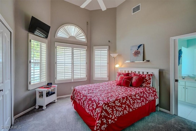 bedroom with a high ceiling, carpet floors, and ensuite bath