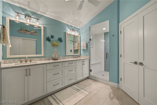 bathroom with lofted ceiling, a sink, a shower stall, and double vanity