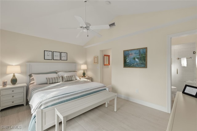 bedroom featuring a ceiling fan, light wood-style floors, vaulted ceiling, baseboards, and ensuite bath