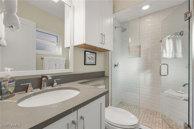 full bath featuring a stall shower, vanity, and toilet