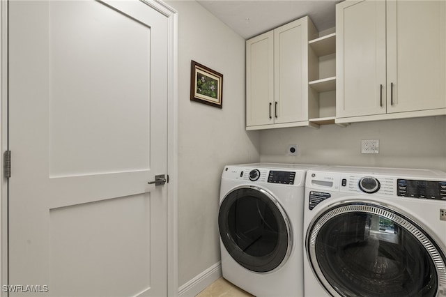 laundry room featuring cabinet space, baseboards, and separate washer and dryer