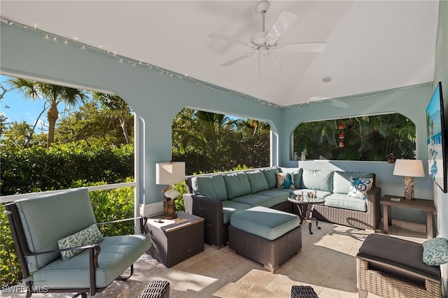 sunroom with ceiling fan and vaulted ceiling