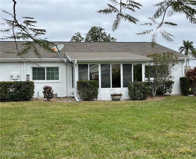 1374 Eagle Way, Fort Myers, FL 33919 - back of property featuring stucco siding, roof with shingles, a sunroom, and a lawn