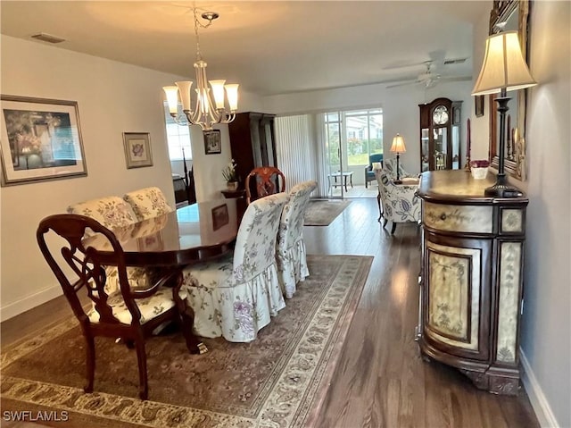 dining room with ceiling fan with notable chandelier and dark hardwood / wood-style floors