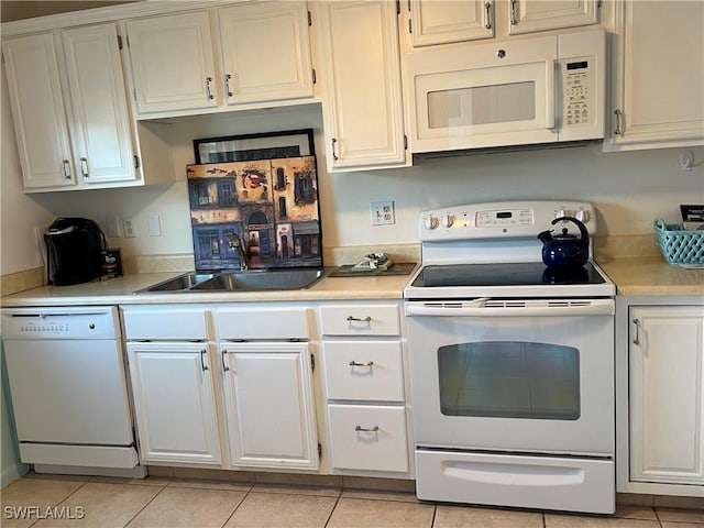 kitchen featuring sink, white appliances, white cabinets, and light tile patterned flooring