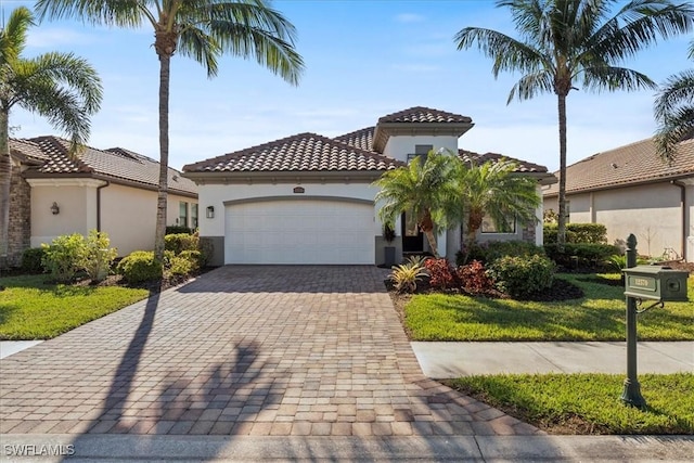 mediterranean / spanish-style home with a garage and a front lawn