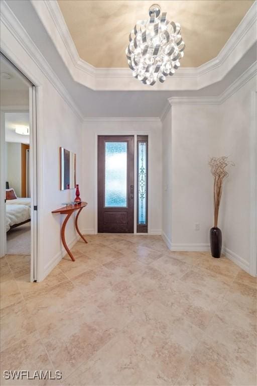 entrance foyer with crown molding, an inviting chandelier, and a tray ceiling