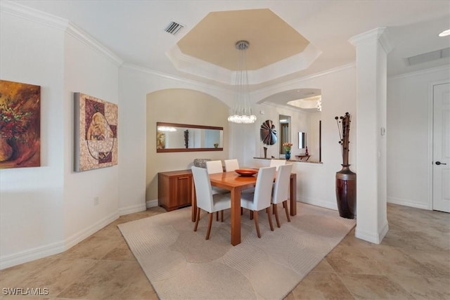 tiled dining room featuring an inviting chandelier, a tray ceiling, and ornamental molding