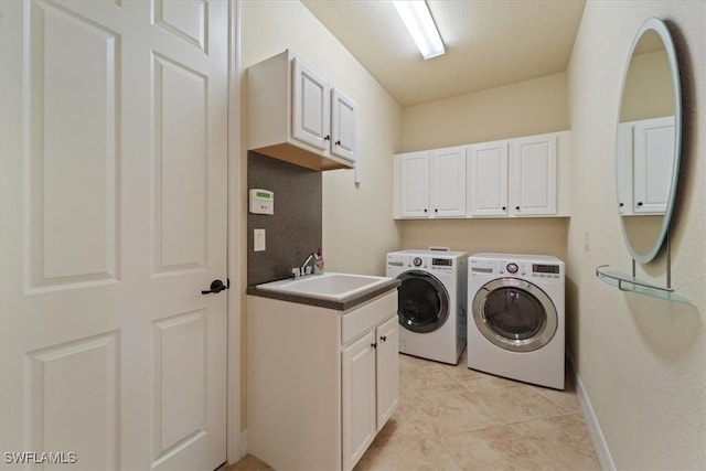 washroom featuring sink, light tile patterned floors, cabinets, and washing machine and clothes dryer