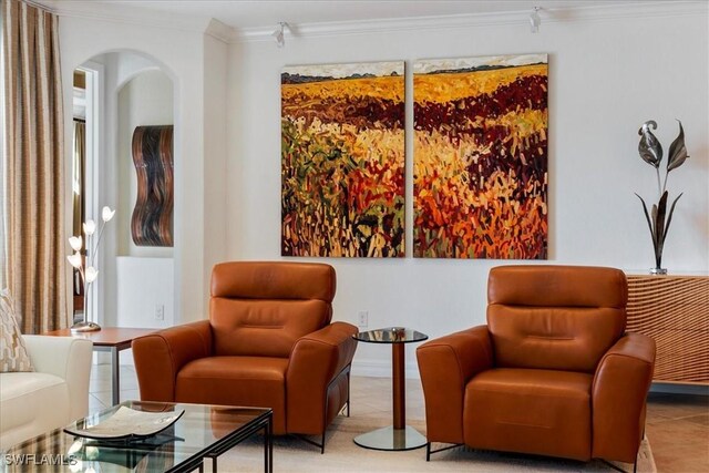 sitting room with crown molding and light tile patterned floors