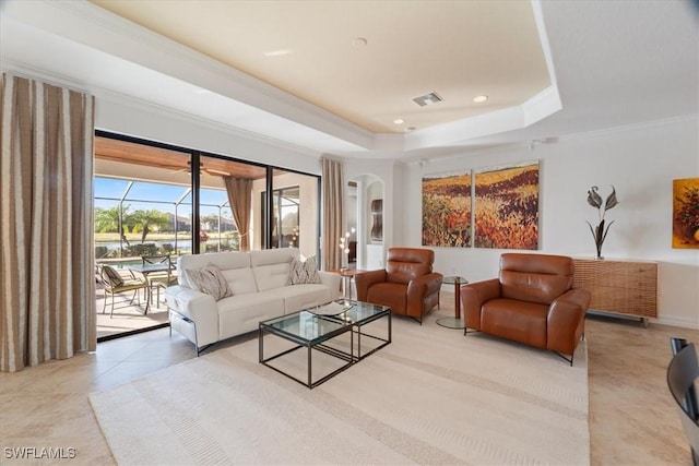 tiled living room with crown molding and a raised ceiling