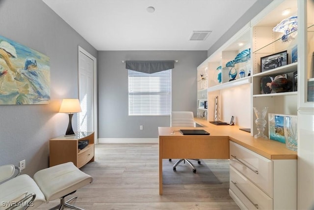 home office with light hardwood / wood-style flooring