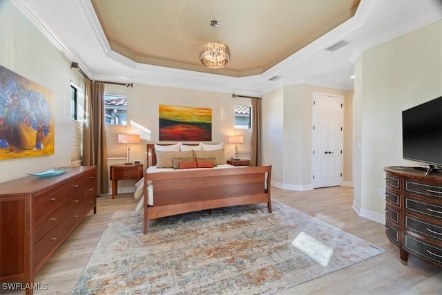 bedroom with crown molding, a raised ceiling, and light wood-type flooring