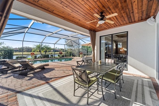 view of patio / terrace featuring glass enclosure and a water view