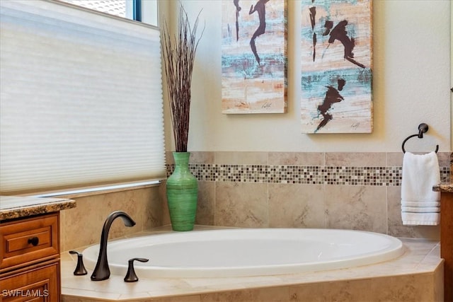 bathroom with vanity and tiled bath