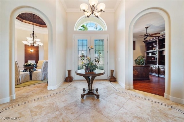 foyer entrance with ornamental molding and ceiling fan with notable chandelier