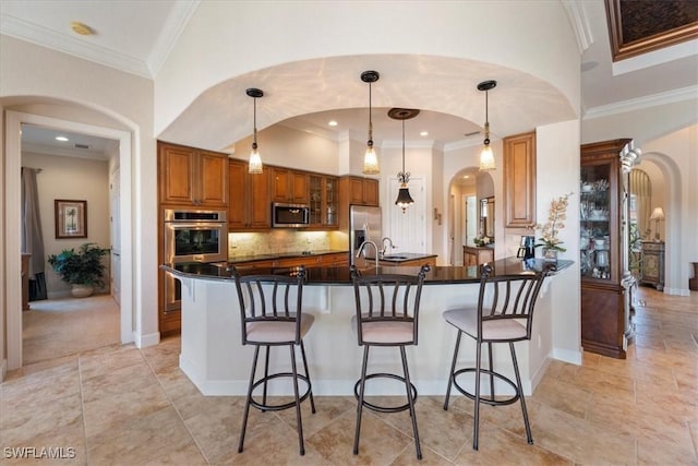 kitchen with hanging light fixtures, appliances with stainless steel finishes, kitchen peninsula, a towering ceiling, and backsplash