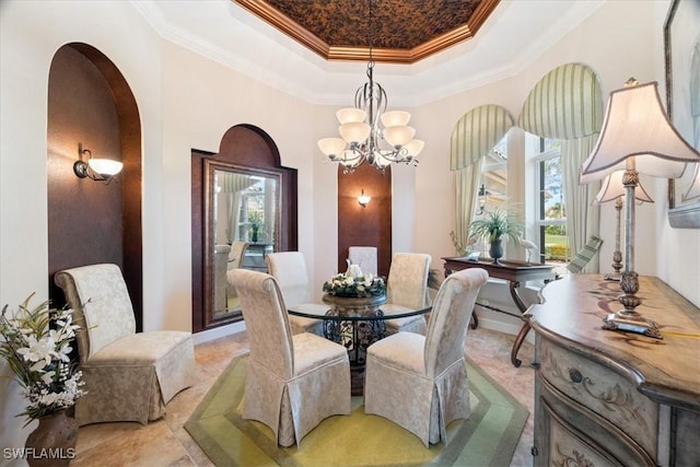 dining space featuring a raised ceiling, crown molding, and a chandelier