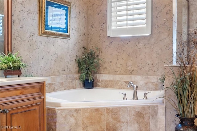 bathroom with vanity and tiled bath