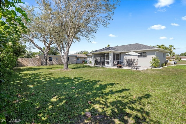 rear view of property with a patio, a sunroom, and a lawn