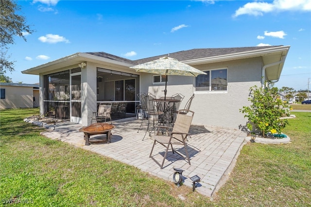 back of house featuring a patio area, a sunroom, a lawn, and an outdoor fire pit