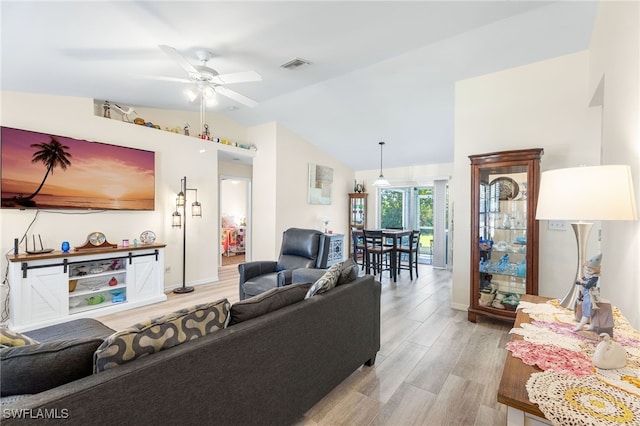 living room featuring ceiling fan, light hardwood / wood-style floors, and lofted ceiling