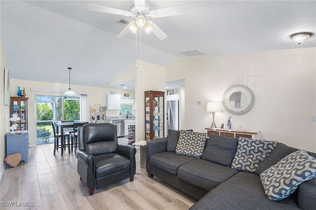 living room with ceiling fan, lofted ceiling, sink, and light hardwood / wood-style flooring