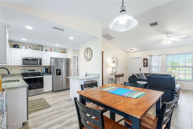 dining room featuring ceiling fan, sink, and light hardwood / wood-style floors