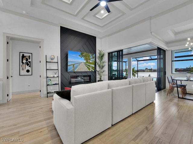 living room with ceiling fan, coffered ceiling, and light wood-type flooring