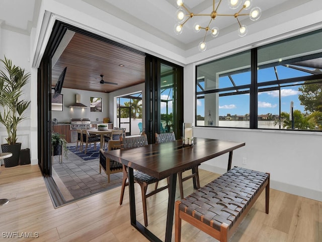 dining room featuring an inviting chandelier, wooden ceiling, light hardwood / wood-style floors, and a wealth of natural light