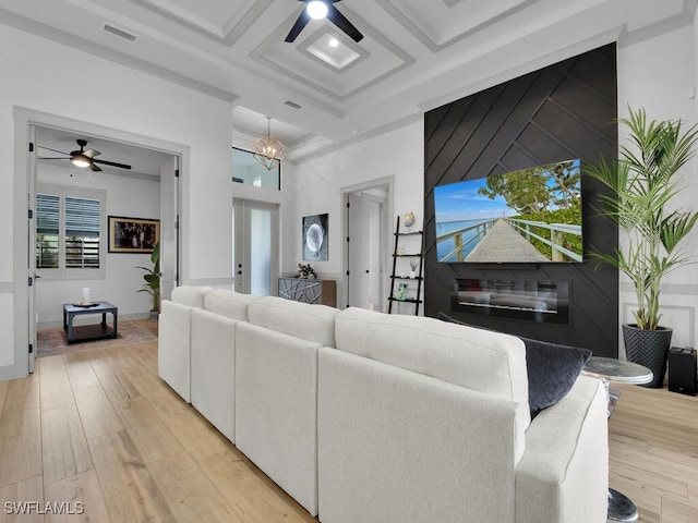 living room with coffered ceiling, beamed ceiling, ceiling fan, and light wood-type flooring