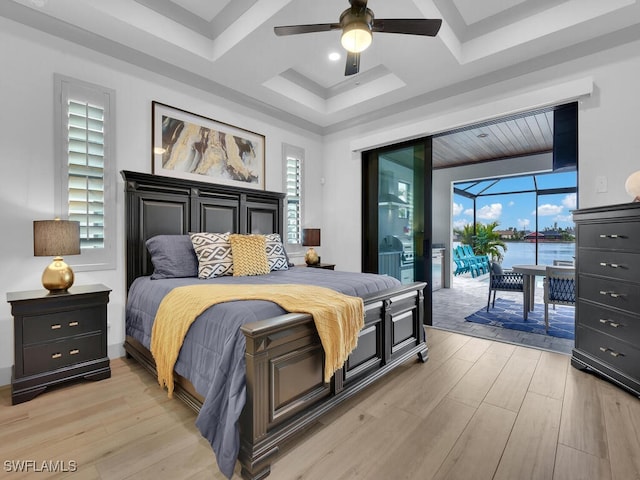 bedroom featuring coffered ceiling, access to outside, ceiling fan, light hardwood / wood-style floors, and a water view